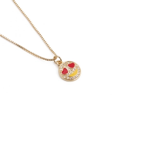 Detailed view of gold smiley pendant with heart eyes and pavé crystals on a box chain