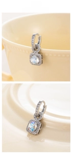 Detail of square zircon drop earrings featuring iridescent center stone and micro-pave crystals