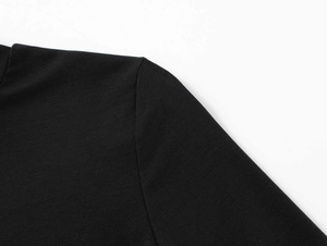 Close-up of black T-shirt shoulder showing fine knit texture and regular sleeve stitching