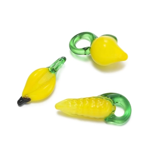 Macro shot of glass vegetable pendants including yellow corn and lemon for DIY jewelry