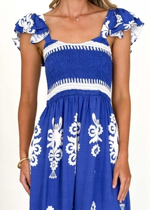 Détail de robe de plage bleue à fleurs avec bustier froncé et manches à volants doux