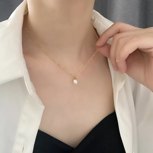 French vintage style natural pearl necklace with gold titanium steel chain on a model
