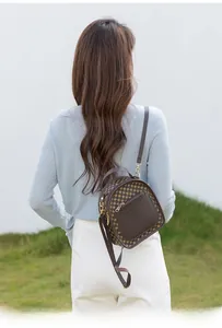 Rear view of a model wearing the brown vintage mini backpack with geometric pattern