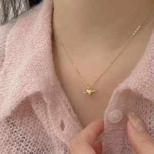 Elegant gold-plated heart planet necklace shown on a model with pink knitwear