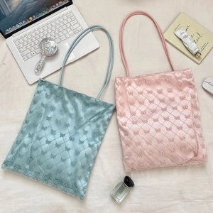 Sacs cabas matelassés avec broderies nœuds en rose et bleu pastel, vue à plat stylée
