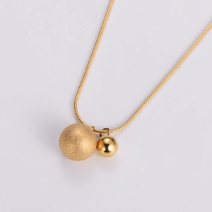 Detailed close-up of gold beaded pendant with matte and polished contrast finish
