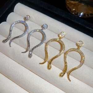 Macro detail of snake earrings in gold and silver plating with pavé cubic zirconia