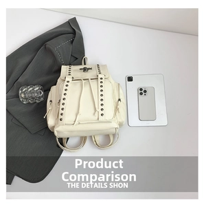 Flat lay of cream-colored backpack with cross rivet decor and metallic skull detail