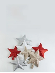 Detail view of sparkling glitter star tree toppers in red, silver, white and champagne gold