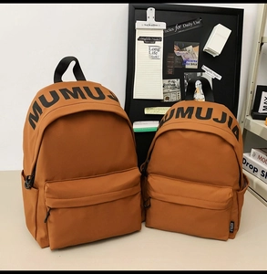 Detail view of two caramel brown nylon backpacks in large and small sizes with front pocket