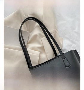 Detail of comfortable shoulder strap and smooth leather texture of black tote bag