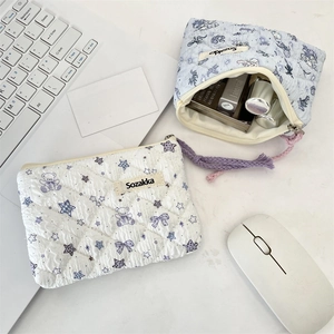 Close-up of quilted floral cosmetic bags with cute bear prints on an office desk