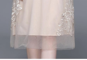 Gros plan sur la broderie florale en tulle champagne et doublure en satin