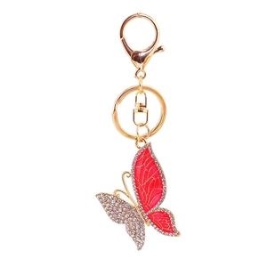 Golden butterfly keychain with red enamel and sparkling crystal rhinestones on white background