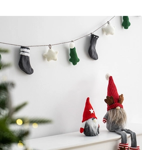 Detail of red Christmas gnomes and knitted ornaments like stars and trees for wall decor