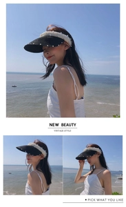 Detail view of women's black straw visor with pearl trim for beach sun protection