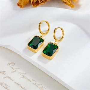 Vintage gold plated earrings with emerald green rectangular gemstones on white background