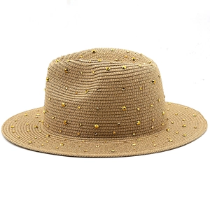Detailed view of woven straw sun hat texture featuring golden rivet studs decor