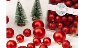 Macro shot of red Christmas balls with glitter and matte textures on snow-like surface