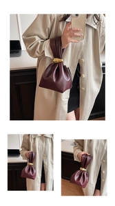 Close-up of deep burgundy drawstring bucket bag with gold knot metal handle detail
