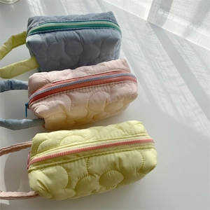 Quilted floral makeup bags in blue, pink, and yellow with contrast color zippers