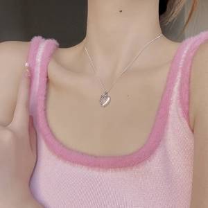 Gros plan d'un collier en argent sterling 925 avec pendentif cœur évidé porté par un mannequin