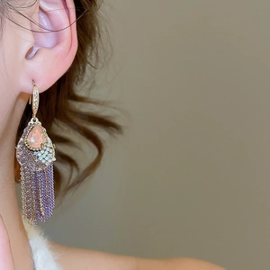 Close-up of vintage pink zircon teardrop earrings with multi-layered tassel chains