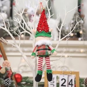Christmas elf doll ornament with red sequins and bell hanging on a white branch