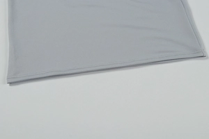 Détail de la double couture et texture en maille fine sur l'ourlet d'une robe grise
