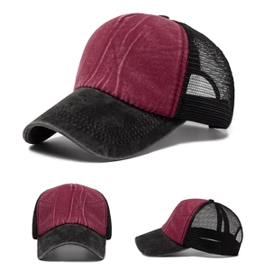 Close-up of distressed burgundy cotton fabric and breathable black mesh on baseball cap