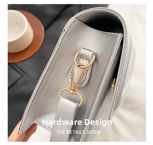 Close-up showing the pale gold metal buckle and silver leather texture of the crossbody bag