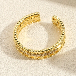 Macro view of gold-plated open ring with heart patterns and zircon stone details
