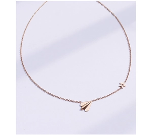 Detail of rose gold paper plane and star pendant necklace in sleek titanium steel