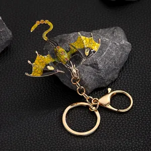 Vintage enamel dragon keychain with sparkling yellow rhinestones on a textured stone base