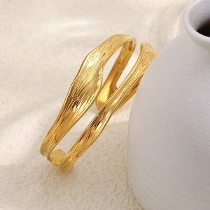 Detail of 18K gold plated bangle featuring a unique irregular lava texture finish