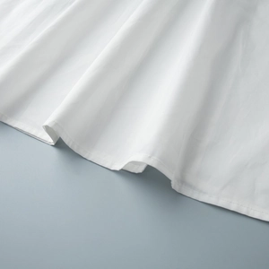 Détail de l'ourlet en coton blanc avec une couture à double aiguille de haute qualité