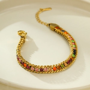 Golden woven stainless steel bracelet featuring colorful zircon gemstones on a white background