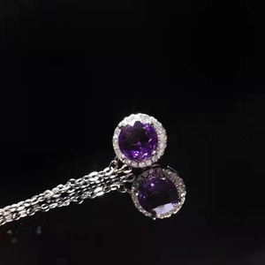 Macro shot of s925 silver necklace with round purple amethyst pendant and halo diamonds