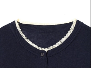 Detail shot of navy blue knit cardigan with delicate white lace trim on the neckline