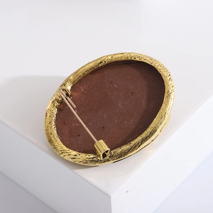 Detailed back view of vintage brooch featuring gold-plated pin and secure clasp closure