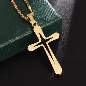 Detailed view of hollow gold cross pendant with beaded chain on a dark textured jewelry box