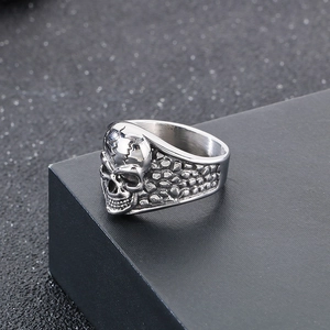 Detail shot of punk skull ring with textured metal finish on black jewelry box