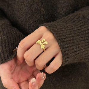 Minimalist S925 sterling silver bow ring in gold finish worn on finger for women
