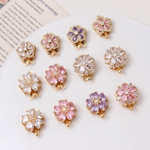 Macro detail of peach blossom jewelry clasps with pink and purple zircon in gold plating