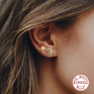 Close-up of S925 sterling silver star and moon stud earrings with sparkling crystals