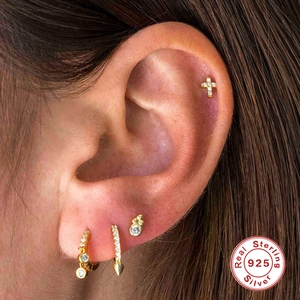 Detail of S925 sterling silver cross earring with diamonds worn on the ear helix