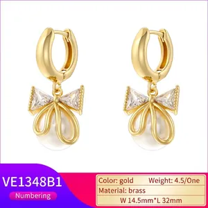 Elegant gold brass bow earrings with white pearls and sparkling cubic zirconia stones