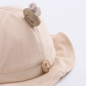 Beige baby corduroy bucket hat featuring love embroidery and decorative top detail