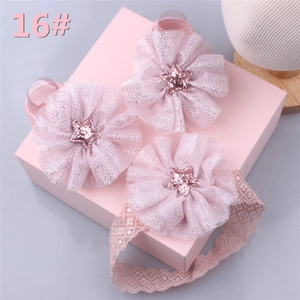 Close-up of pink lace baby headband set with glitter star and tulle flower details