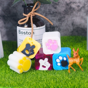Macro detail of cat paw silicone resin molds in various colors on a green lawn